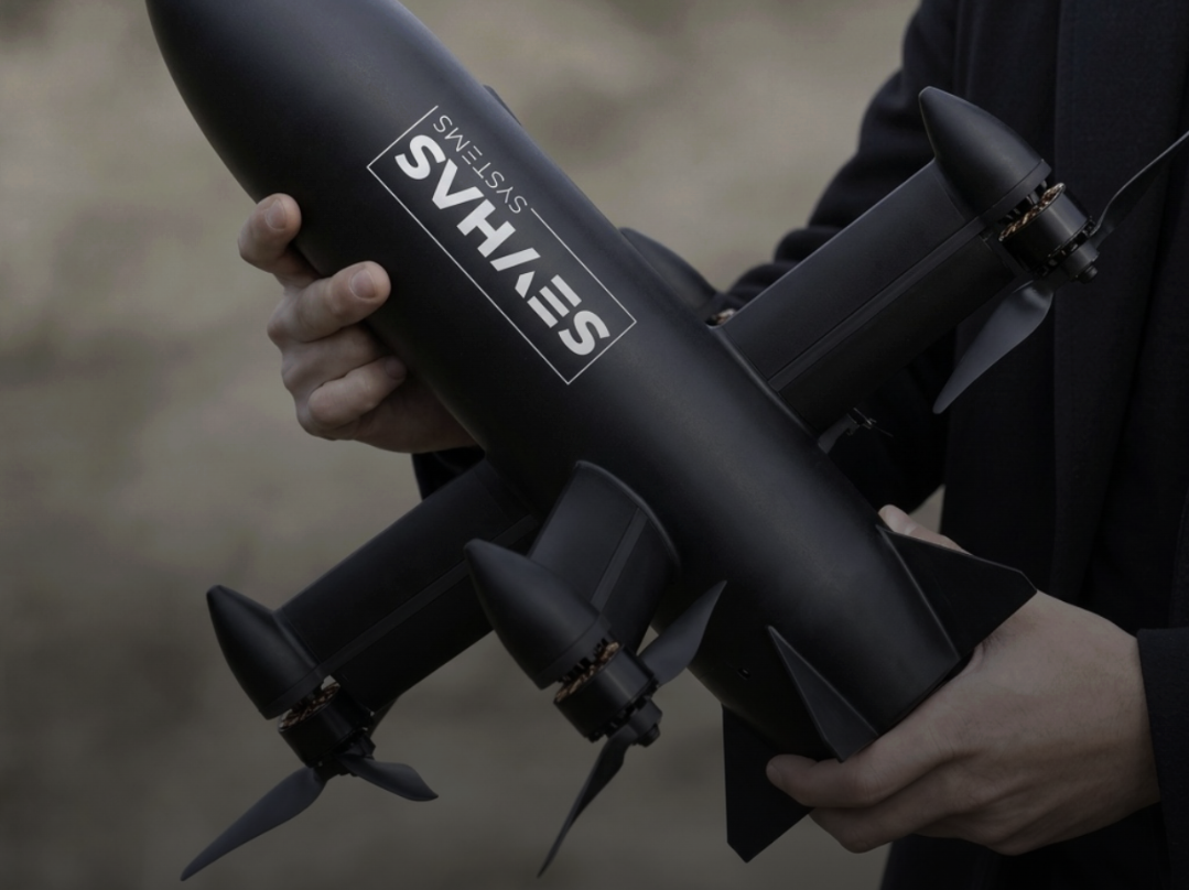 Pilot holding a black SevHas FPV aircraft